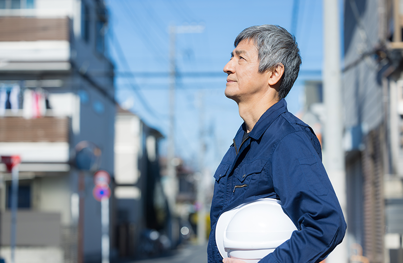 住宅街にいる高齢の作業員