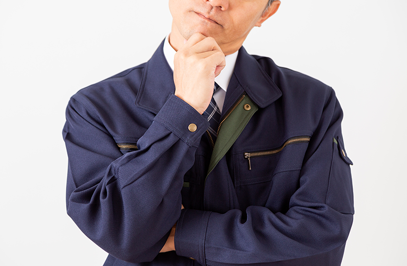 作業服を着た悩む男性